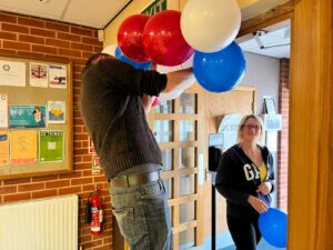 Putting up red blue and white balloon arch