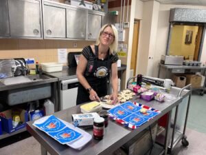 Becky preparing scones with jam and cream